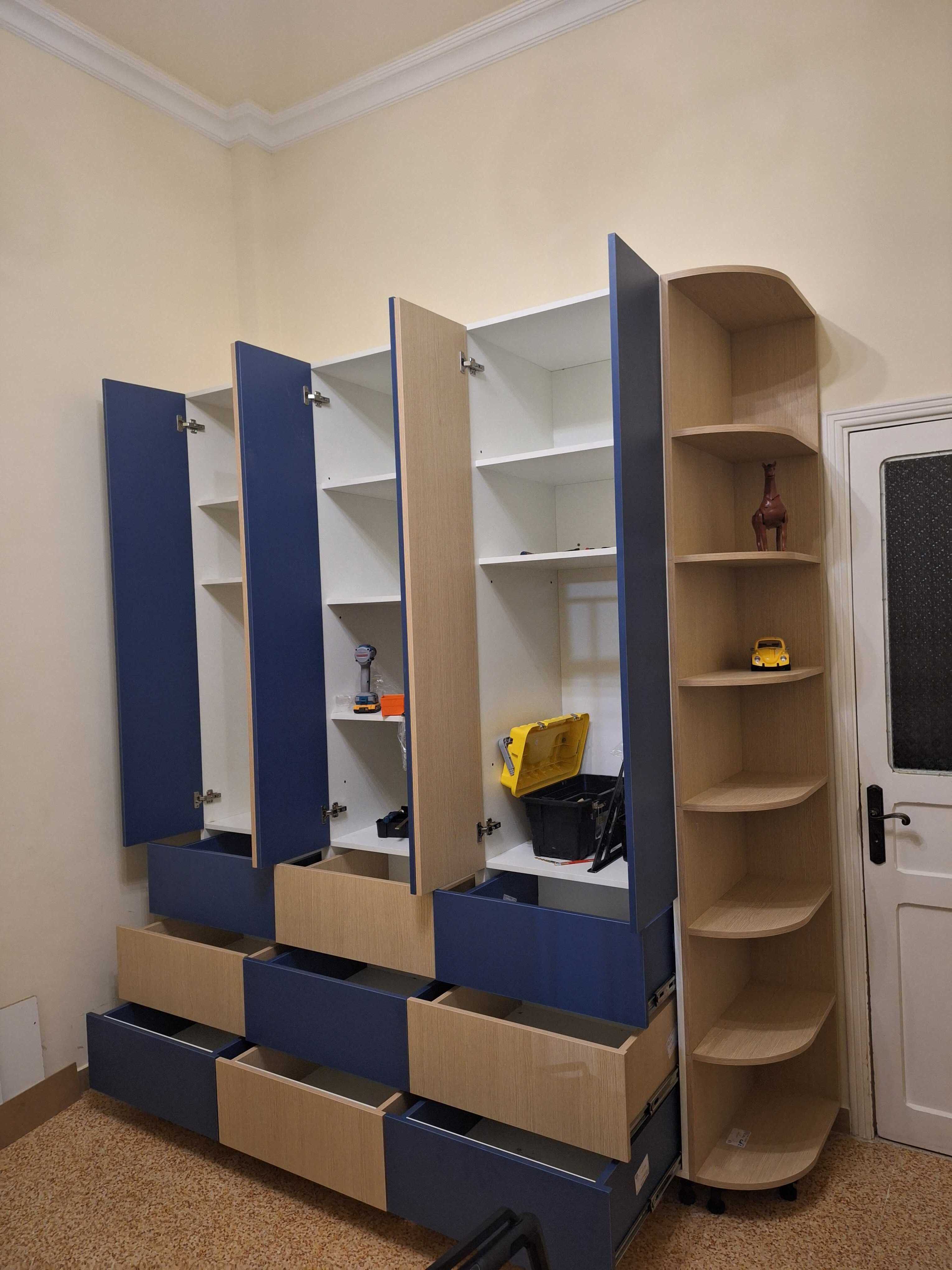 Kids' wardrobe with its cabinet doors and drawers open to show the storage inside